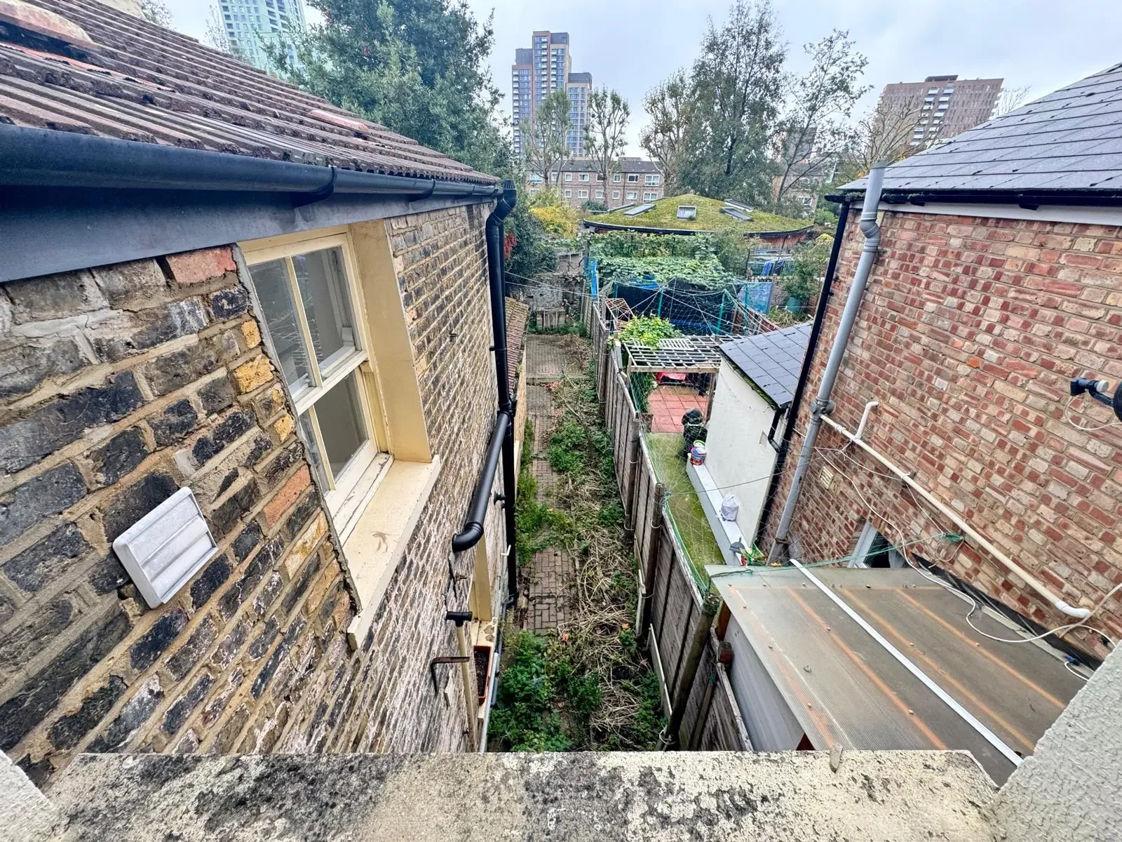 External inspection of rear elevation and drainage during a Level 2 Homebuyer Survey in the UK