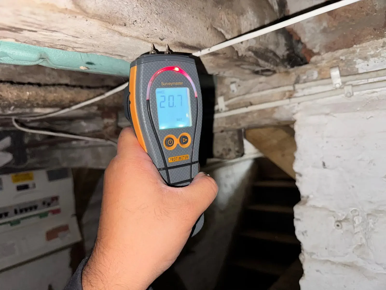 Level 2 Homebuyer Survey inspection using a moisture meter to check timber condition beneath a floor